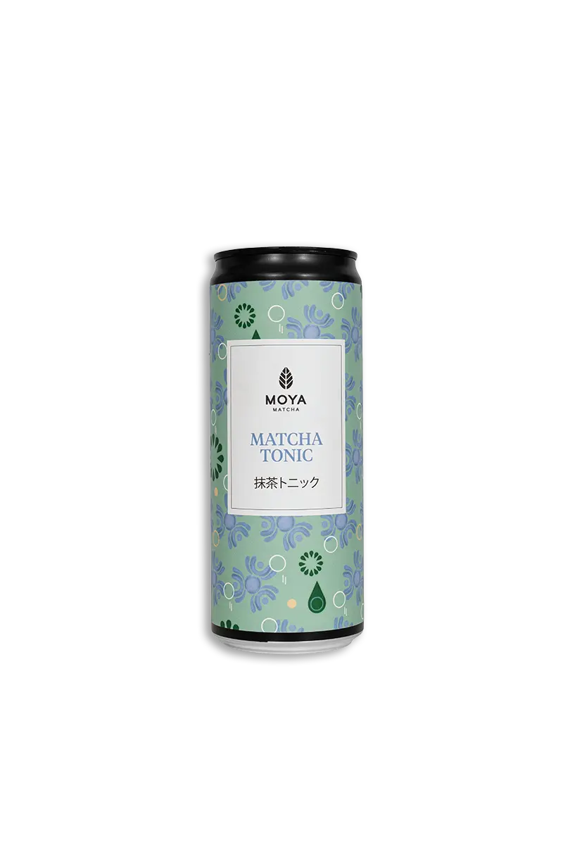 En 330 ml boks med Moya Matcha Tonic i lysegrønne og blå nyanser, dekorert med et subtilt botanisk motiv, presentert i midten på en ren hvit bakgrunn.